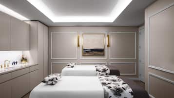 A modern hotel room with a skylight, a large painting, and a neatly arranged bed with a floral bedspread.