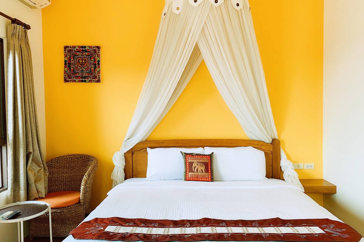 A room with a bed, a chair, and a table.