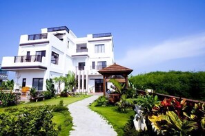 A modern multi-story building with a well-maintained garden and a gazebo. - Ibali B & B (Magong)