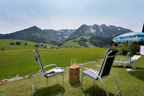 A scenic outdoor seating area with two chairs and a table, overlooking a mountainous landscape. - Hotel Garni Tirol (Walchsee)