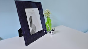 A framed photograph on a white surface with a green vase and a silver object. - STSP Guest House (Tainan)