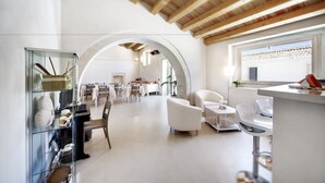 Ett rymligt matområde med högt i tak och välvda dörröppningar, inrett med vita möbler och en modern design.