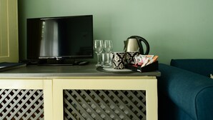 Une télévision, deux verres, une machine à café et un porte-magazines sur un comptoir.