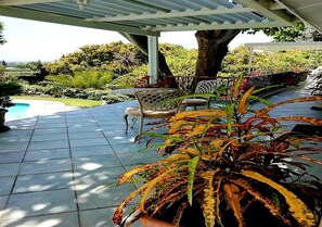 A covered patio area with a pool, chairs, and potted plants. - De Wingerd Wijnland Lodge (Paarl)