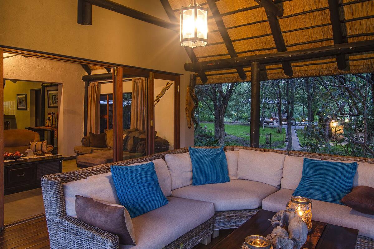 A cozy living room with a large sectional sofa, a wooden coffee table, and a view of the outdoors.