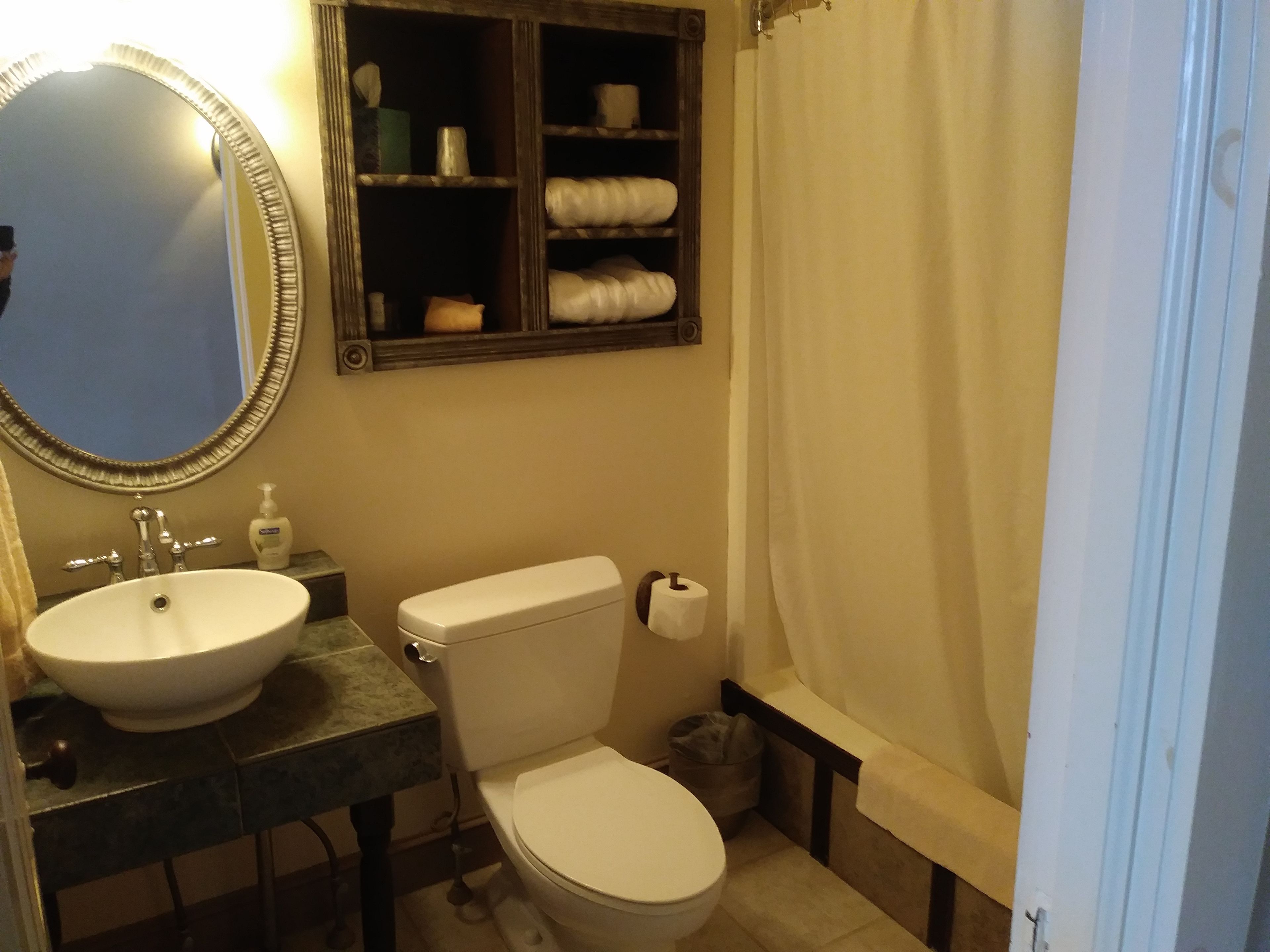 Un baño con lavamanos, inodoro y espejo.