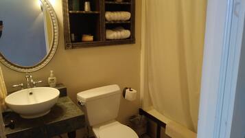 Un baño con lavamanos, inodoro y espejo.