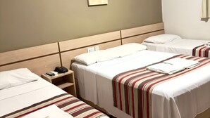 A hotel room with two beds, a bedside table with a phone, and a wall-mounted artwork. - Hotel Villa Rebellato (Olímpia)