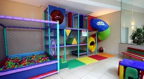A children's play area with a ball pit, climbing structures, and a slide.