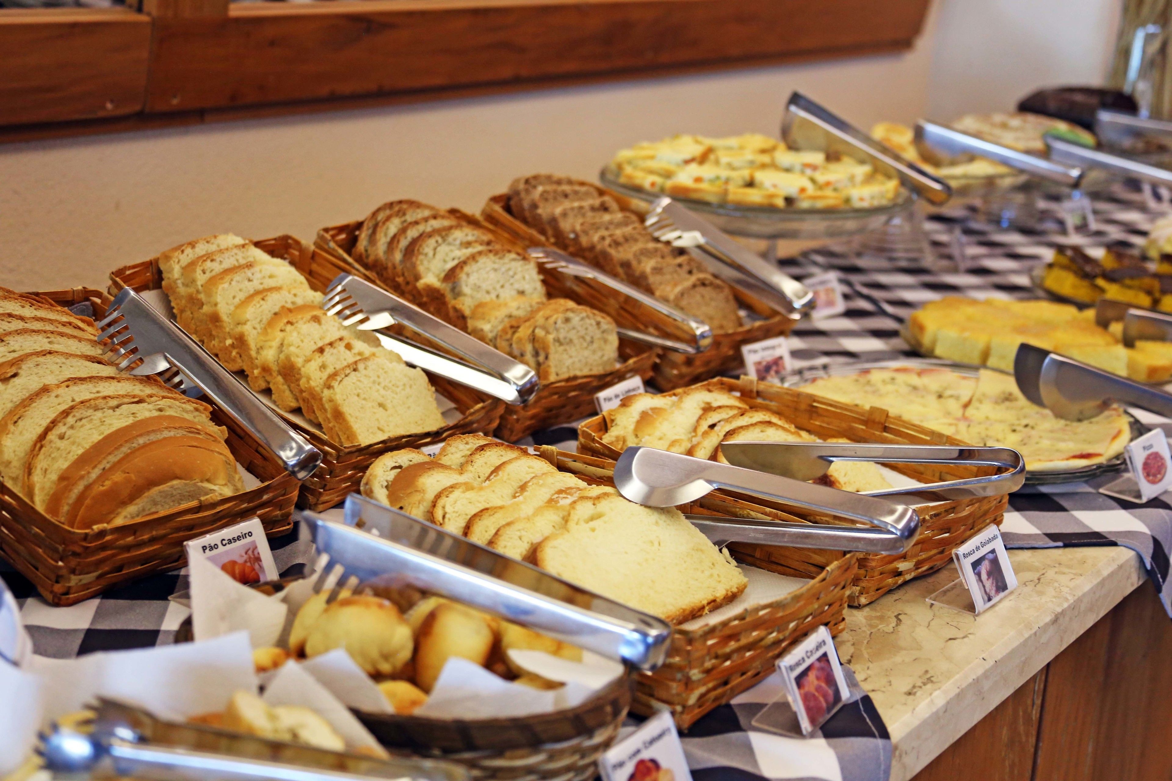 Un bufé con diferentes panes y pasteles exhibidos en cestas.