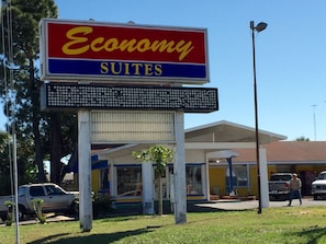 A sign for Economy Suites with a digital display below it. - Economy Suites (Winter Haven)