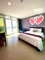 A bedroom with a bed, a desk, and a chair.