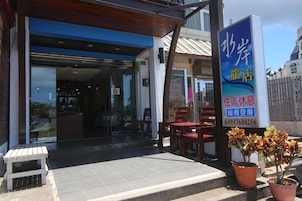 A traveler's accommodation with a visible entrance, seating area, and a signboard.