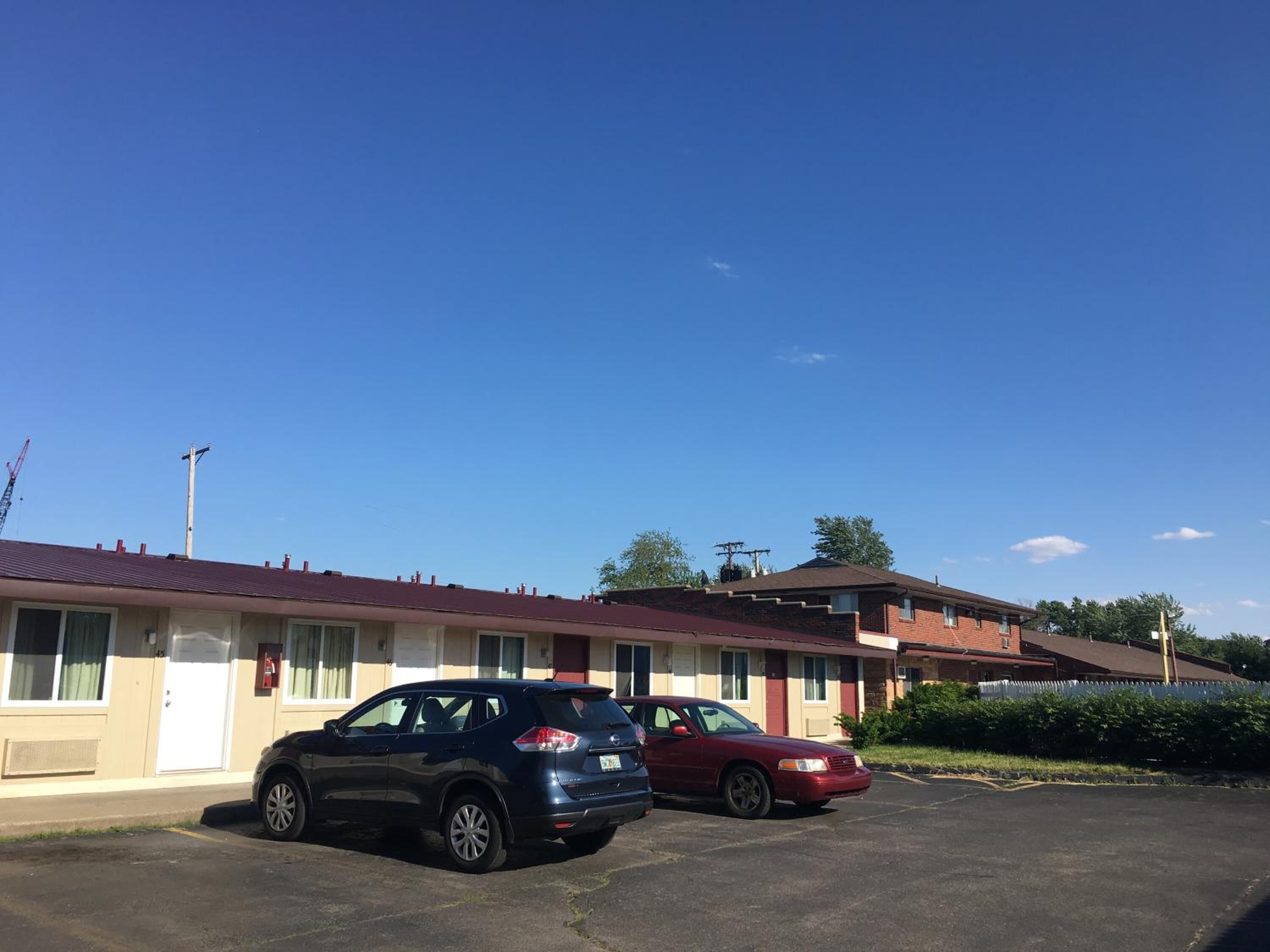 Un motel con dos coches estacionados en el estacionamiento.