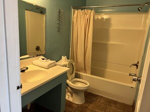 A bathroom with a sink, toilet, and shower. - Crown Inn (Toledo)