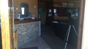 A reception area with a brick counter, a mirror, and a 'Reception' sign.