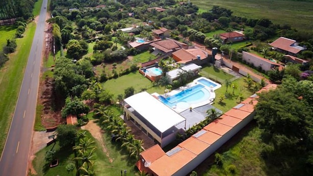Vista aèria d'una zona residencial amb cases, una piscina i una carretera.