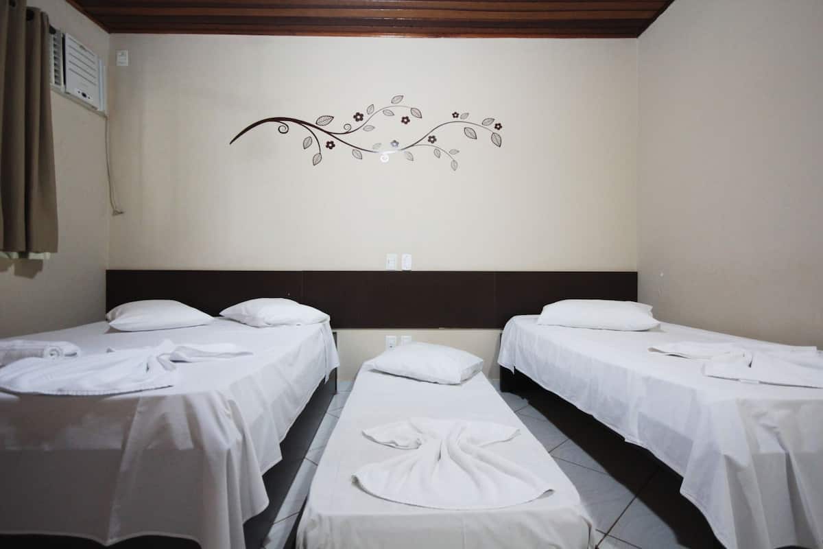 Une chambre d’hôtel avec deux lits simples, une décoration murale et un plafond en bois.