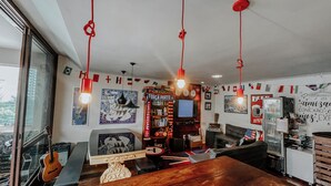 Un salon chaleureux avec une table en bois, une guitare et une bibliothèque.