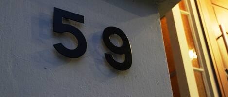 A building number '59' on a white wall.