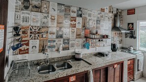 Une cuisine dotée d’un long plan de travail, d’un évier à deux bacs et d’armoires en bois.