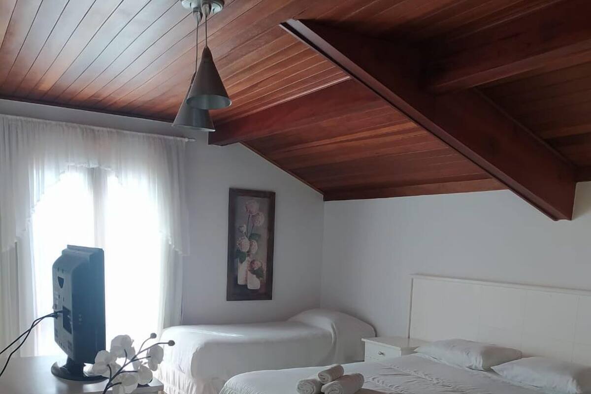 Un dormitorio con dos camas, un escritorio, una computadora y un ventilador de techo.