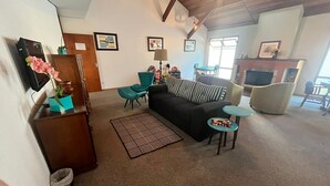 A living room with a sofa, chairs, a coffee table, and a patterned rug. - Pousada Condado Brasileiro (Campos do Jordão)