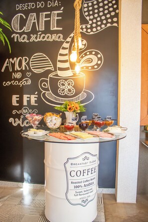 A breakfast buffet with a coffee station and a chalkboard with text and drawings.