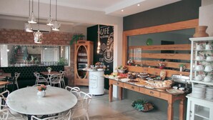 Ein gemütliches Café mit Backsteinwand, Holzmöbeln und einer Auswahl an Speisen und Getränken hinter der Theke.