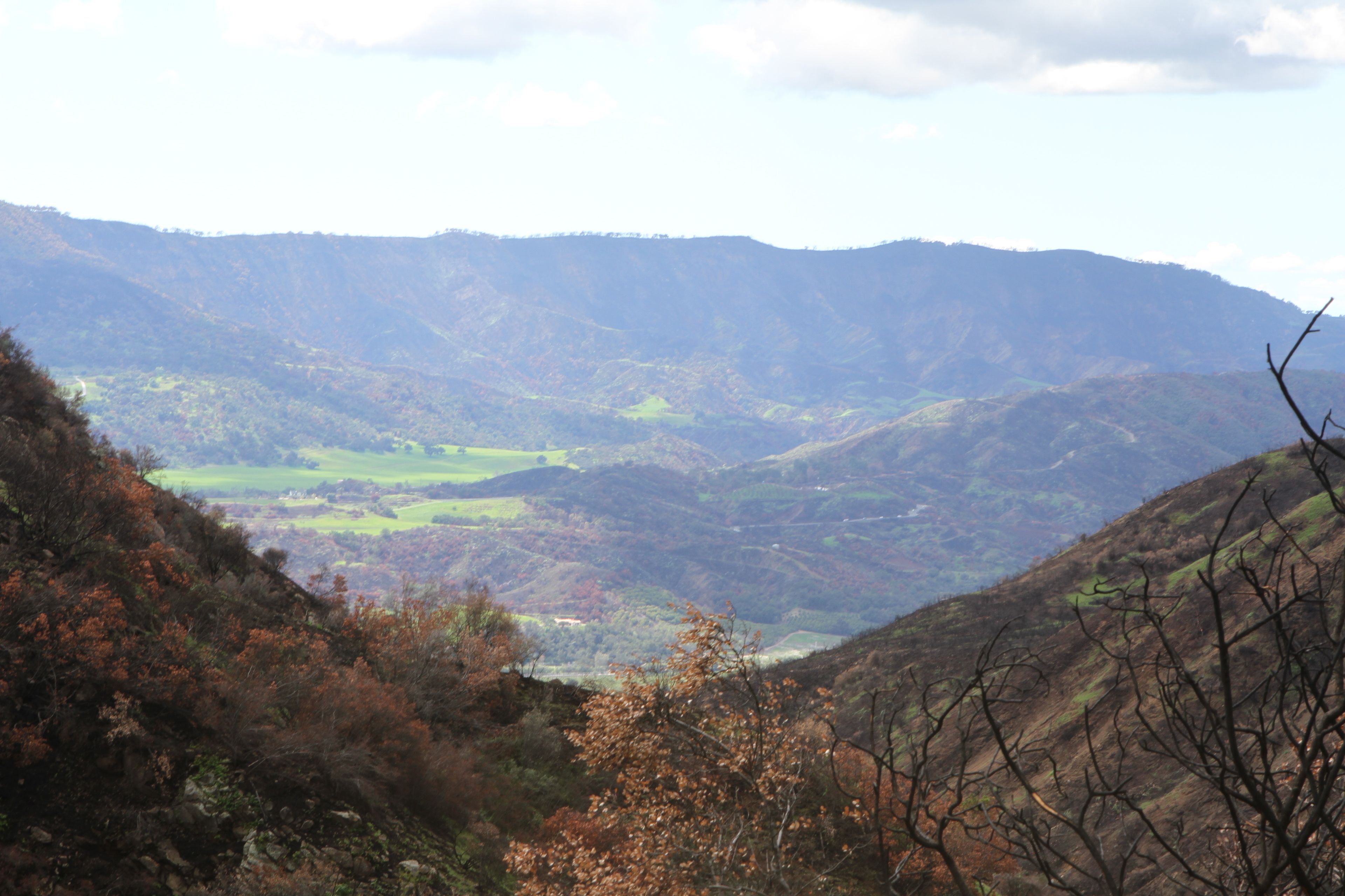 A mountainous landscape with a valley and a river.