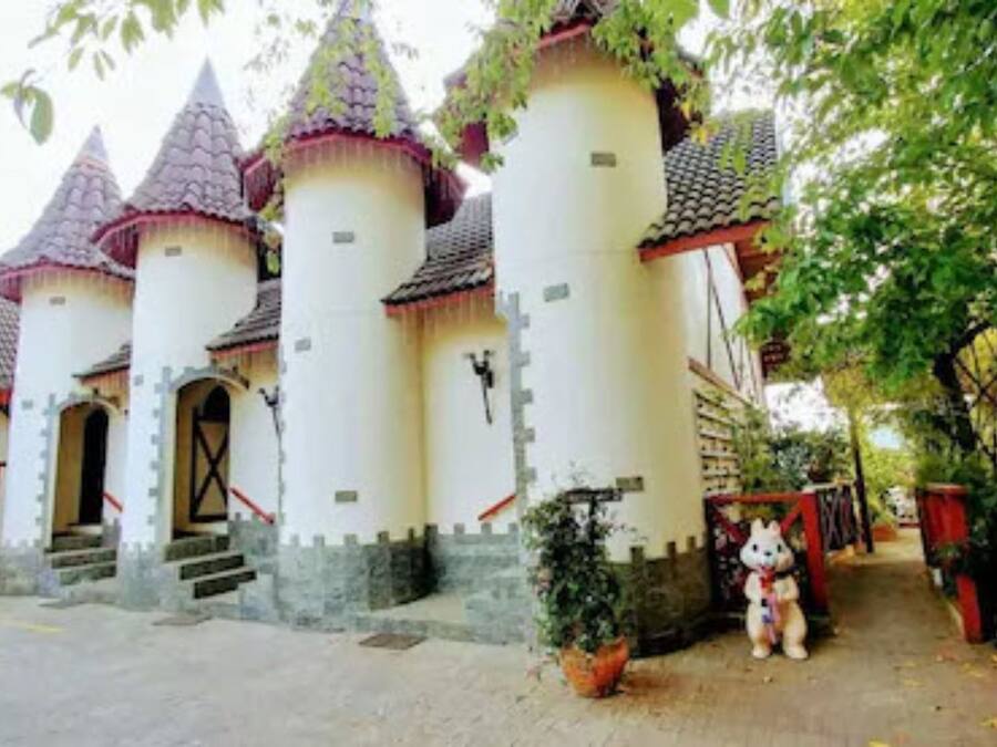 A castle-like building with multiple towers and a red telephone booth.
