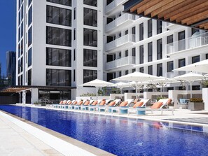 Piscine extérieure, parasols de plage, chaises longues