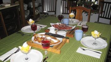 A dining table set with plates, glasses, and cutlery, surrounded by chairs.