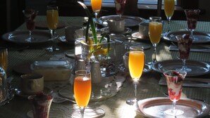 Un desayuno con diversas bebidas y platos sobre una mesa.