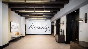 Un pasillo con un gran mural, una recepción y un moderno sistema de iluminación.