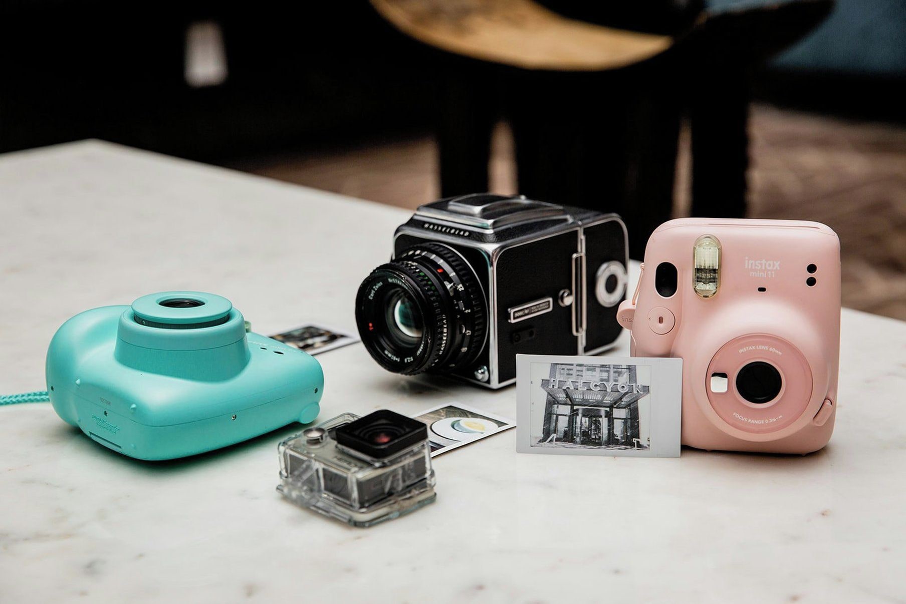 A table with three cameras and a photo card.