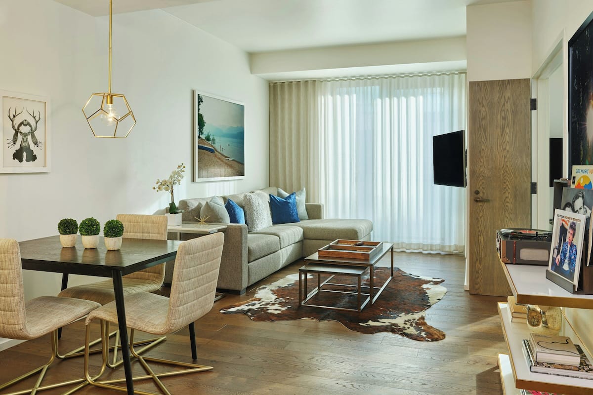 A modern living room with a dining table, sofa, and coffee table.