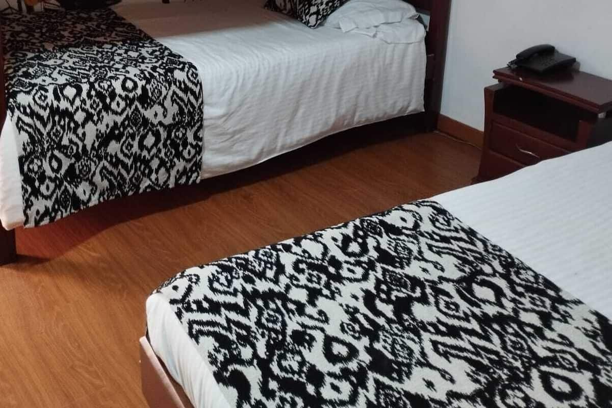 Une chambre avec des lits superposés, dotée de draps à motifs et d’une fresque murale.