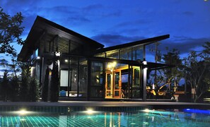 A modern house with large glass windows, a swimming pool, and a covered outdoor area. - Family House Zen Boutique Resort (Pai)