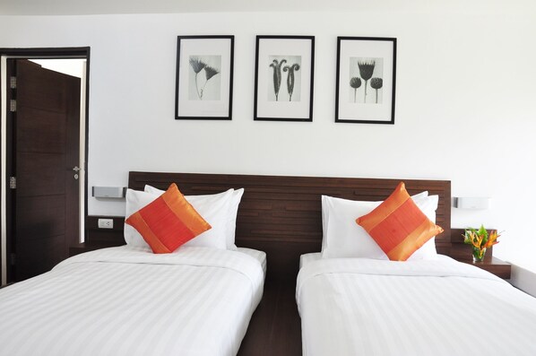 A hotel room with two beds, a wooden headboard, white bedding, and three framed botanical prints on the wall. - Family House Zen Boutique Resort (Pai)