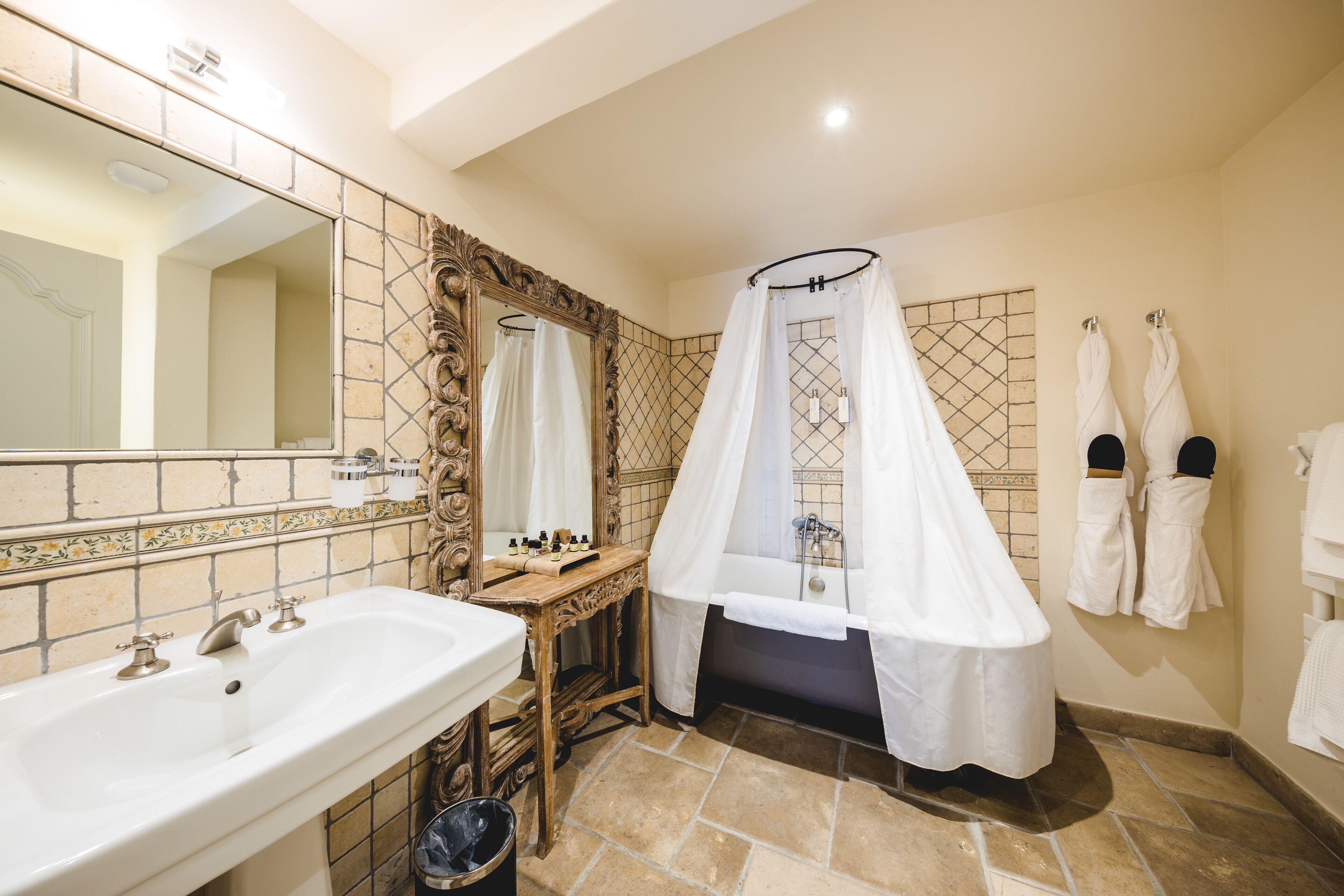 A bathroom with a large mirror, a sink, a bathtub, and a shower curtain.