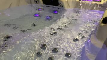 Un bain à remous avec des bulles et une lumière violette.