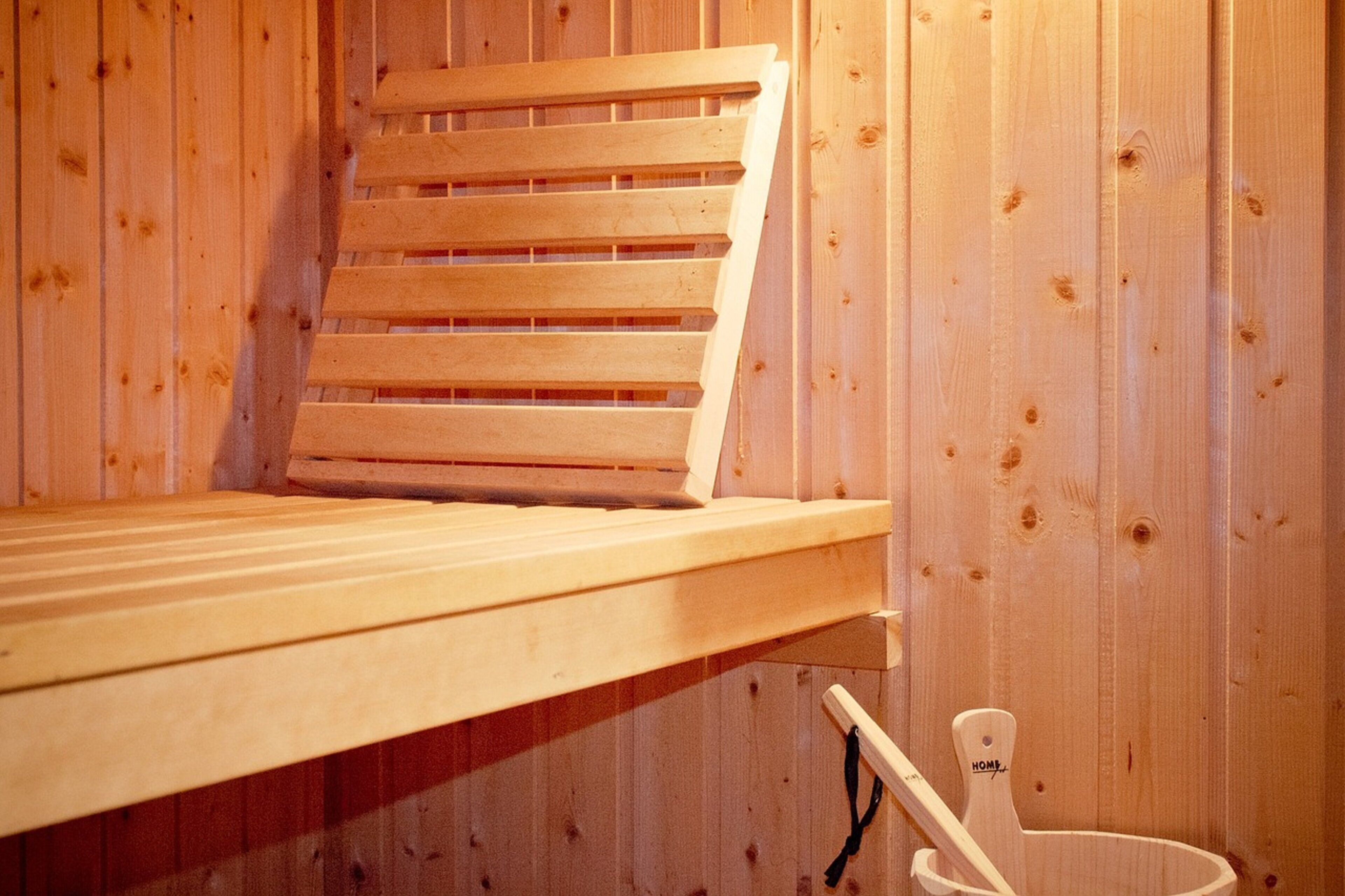 Un letto a castello in legno con testiera a listelli e un letto singolo sottostante.