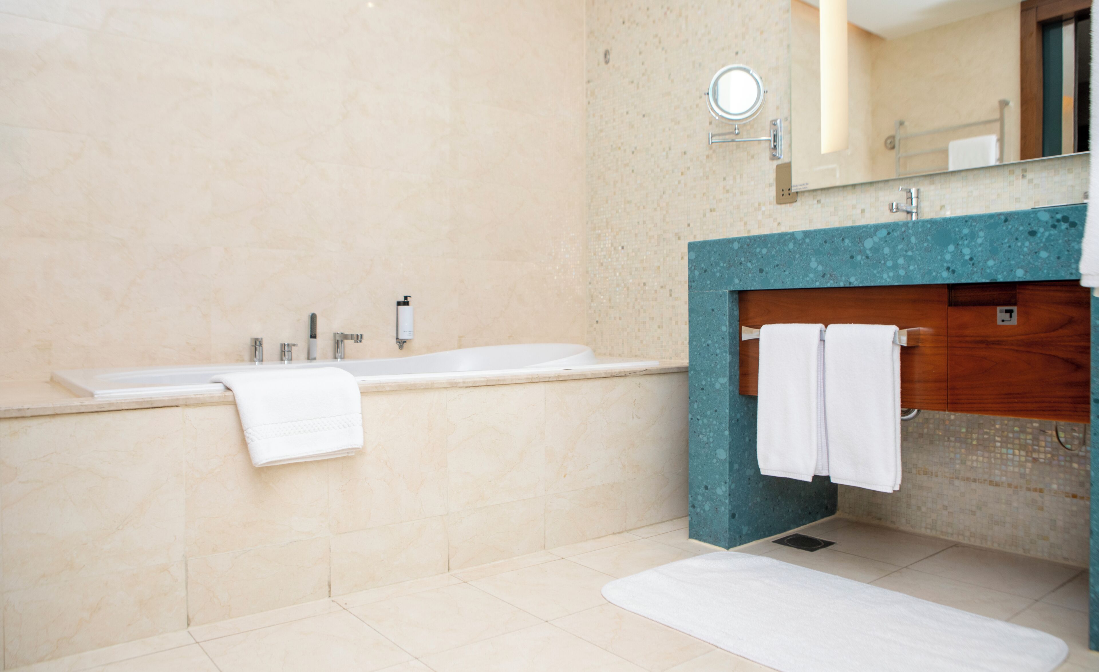 Une salle de bain avec une baignoire, un lavabo et un miroir.