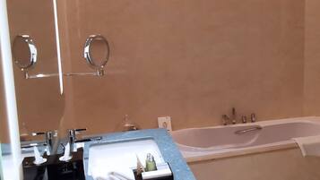 A bathroom with a bathtub, a sink, and a mirror.