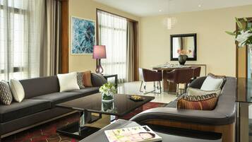 A modern living room with a sofa, coffee table, and dining area.