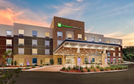 A Holiday Inn Express building with a modern design, featuring a stone facade and a covered entrance.