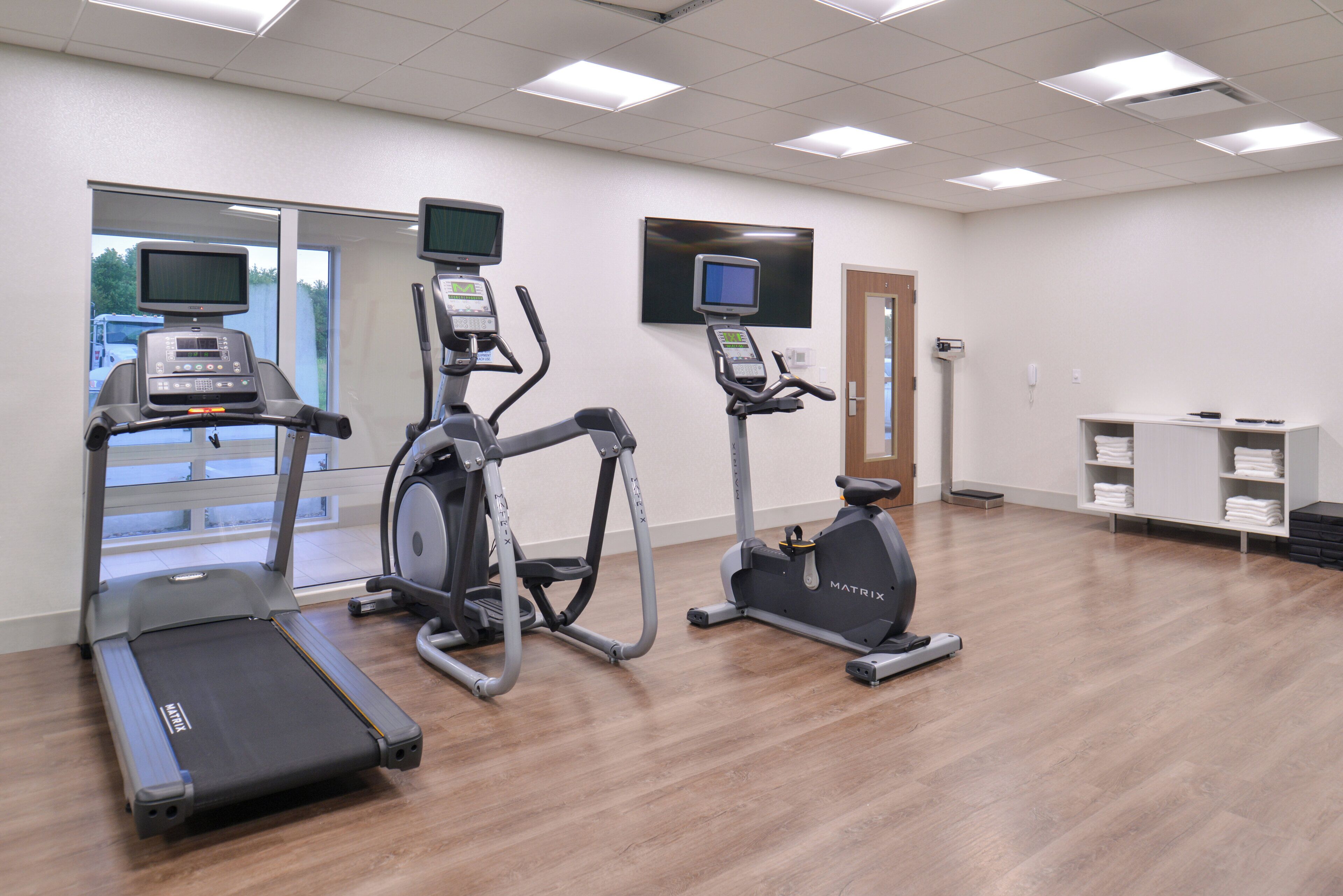 A fitness center with treadmills, elliptical machines, and a stationary bike.