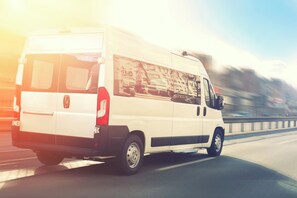 Una camioneta blanca circulando por una autopista.