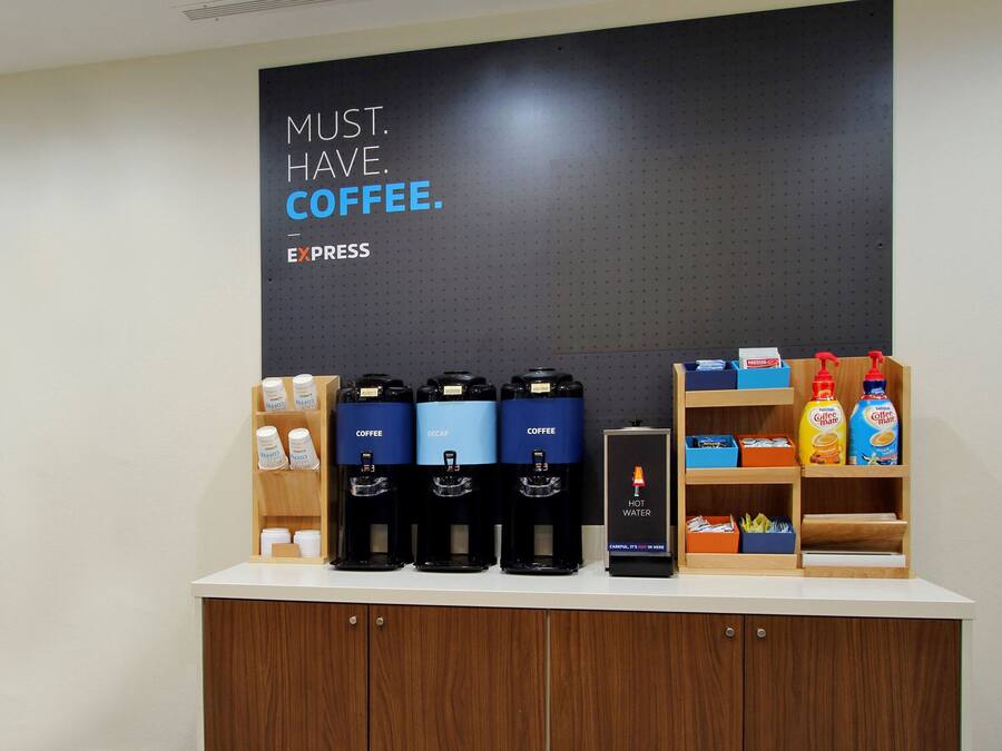 Un espace dédié au café, équipé de plusieurs distributeurs de café, d’un point d’eau chaude et proposant divers produits à base de café.